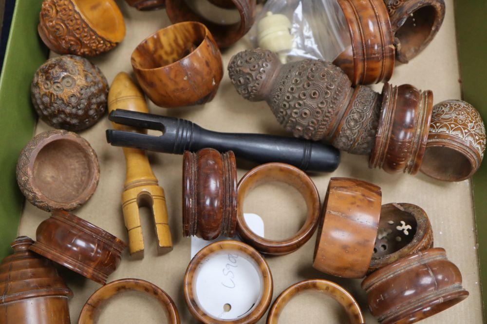 A 19th century ivory humming top, a coquilla nut humming top and a group of coquilla nut carvings and napkin rings